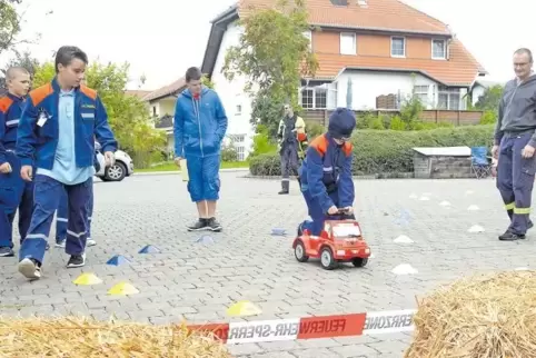 Einer fährt, vier lenken bei der Hindernisfahrt auf dem Feuerwehr-Bobbycar.