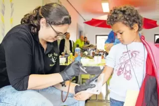 Anziehungspunkt für große und kleine Kinder: die Tattoo-Station – hier erhält die vierjährige Anna von Natalie Schott (beide aus