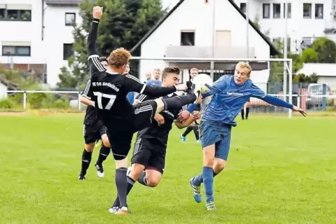 Hoch das Bein: Dennis Hinkel (links) vom FC Rodalben klärt vor Thomas Stanjek (rechts) vom FC Merzalben. In der Mitte Max Chungu