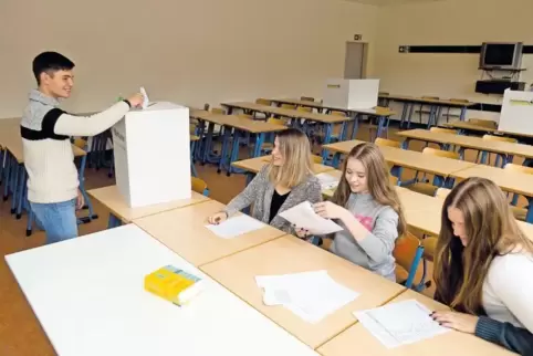 Ganz wie bei den Erwachsenen: Schüler Tim Wamsbach gibt seine Stimme ab, die Wahlhelferinnen Marie-Christine Steil, Tabea Berger