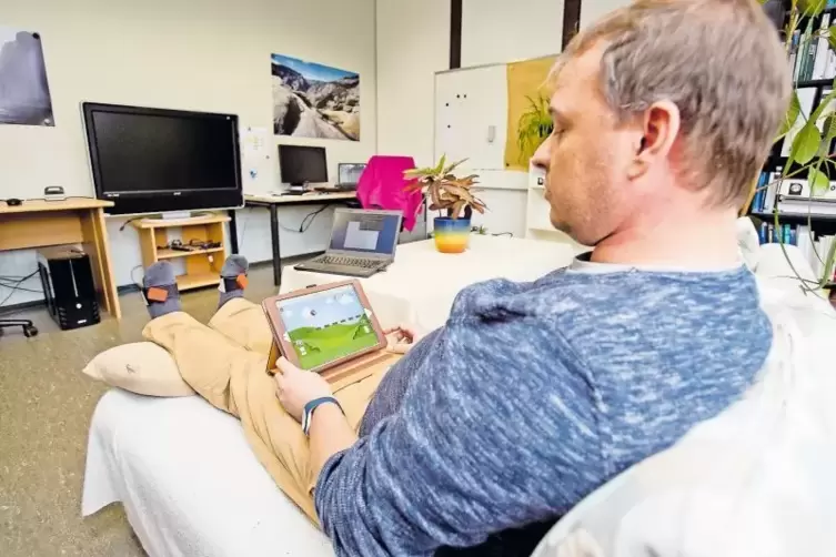 Sensoren an den Füßen registrieren die Bewegungen und übertragen sie in das Computerspiel, das Daniel Steffen auf dem Tablet-PC 