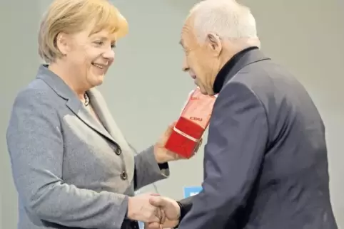 Angela Merkel überreicht im März 2010 im Konrad-Adenauer-Haus in Berlin dem 80-jährigen Heiner Geißler ein Geburtstagsgeschenk. 