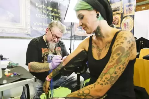 Für die Schönheit: Gerald Neubert von Buzzin Needles Tattoo sticht bei der Tattoo Convention in Hohenecken Fee Huber ein neues T