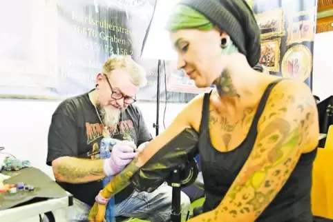 Für die Schönheit: Gerald Neubert von Buzzin Needles Tattoo sticht bei der Tattoo Convention in Hohenecken Fee Huber ein neues T