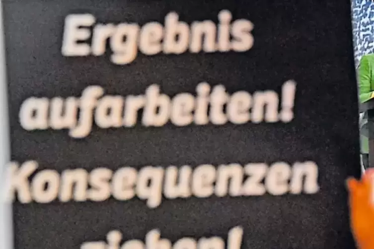 Als Angela Merkel auf dem Deutschlandtag der Jungen Union redet, halten Delegierte Schilder mit Forderungen hoch.