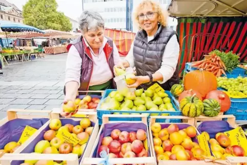 Gudrun Weißmann und Maria Schneider verkaufen an ihrem Stand auf dem Wochenmarkt Äpfel in allen Farbschattierungen.