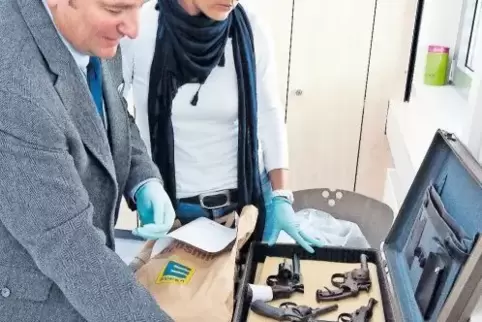 Michael Edinger und Claudia Steinbach mit Waffen, die die Polizei nach einem Gewaltverbrechen sichergestellt hat.
