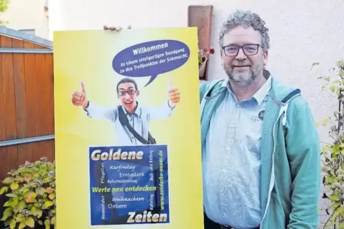 Da, schau her: Bernd Mikoteit von der evangelischen Freikirche in Mutterstadt mit dem Plakat für die Ausstellung.
