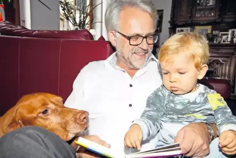 Mehr Zeit für die Familie: Peter Eberhard in seinem Wohnzimmer mit Enkel Hannes, der 2016 geboren wurde, und Hund Fino.