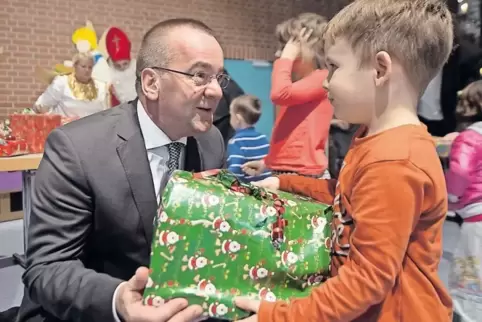 Niedersachsens Innenminister Boris Pistorius übergibt bei einer Weihnachtsfeier der Landesaufnahmebehörde im Lager Friedland ein