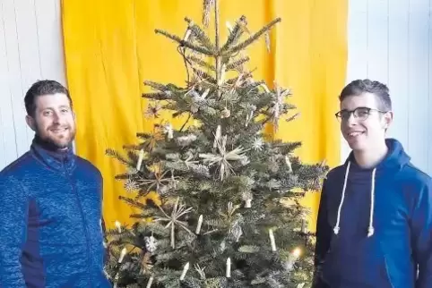 Michael Schwall (links) und David Mittag haben einen Baum für den Schulgottesdienst nur mit Kerzen und Strohsternen geschmückt.