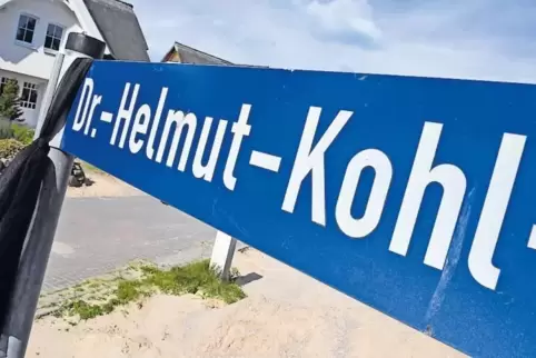 Großes Bild: Ein Trauerflor hängt an einem Straßenschild der „Dr.-Helmut-Kohl-Straße“ in Loddin in Mecklenburg-Vorpommern. Daneb