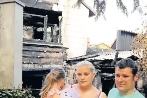 Mia, Denise und Mirco Trinkaus im Sommer vor der Brandruine in der Paul-Münch-Straße.