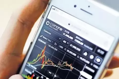 Ein Anleger in Korea studiert den Kurs der Bitcoin-Währung auf seinem Smartphone.