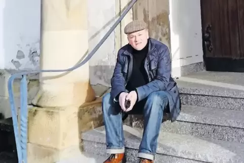 Mit der „Batschkapp“ auf der Kirchentreppe: Pfarrer Thomas Becker verlässt bald die Pfarrei St. Franz Xaver in Lauterecken.