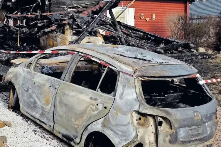 Eines der ausgebrannten Autos, dahinter der Carport.