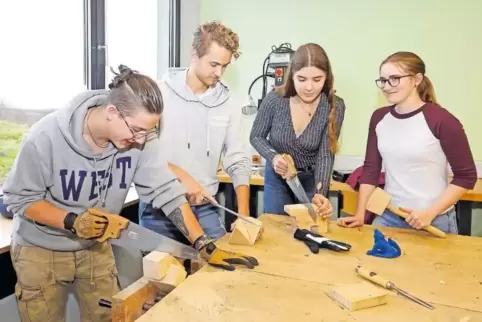 Nino, Marcel, Alexandra und Linda (von links) üben sich beim Tag der offenen Tür im Werkraum im Gebrauch mit verschiedenen Werkz