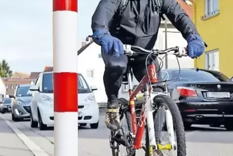 Stehen am Rand des Gehwegs in der Berghäuser Straße in Römerberg: rot-weiße Metallpfosten.