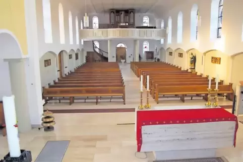 Blick vom Altarraum in das Kirchenschiff mit Empore. Hinten ist das versetzte Taufbecken zu sehen.