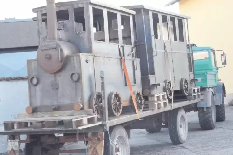 Zwei Waggons (nebeneinander platziert) und eine Lok machen sich gut verzurrt auf die Reise ins Zwischenlager.