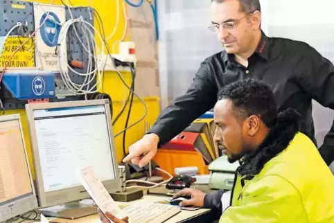 Im Betrieb von Daniel Huying (hinten) gehört es zu den Aufgaben von Mohammed Abdi Sulayman, die Produktdaten und den Zustand von