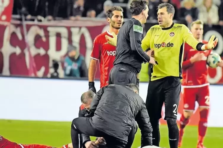 Der verletzte Marcel Correia liegt am Boden, FCK-Keeper Marius Müller diskutiert mit Schiedsrichter Manuel Gräfe.