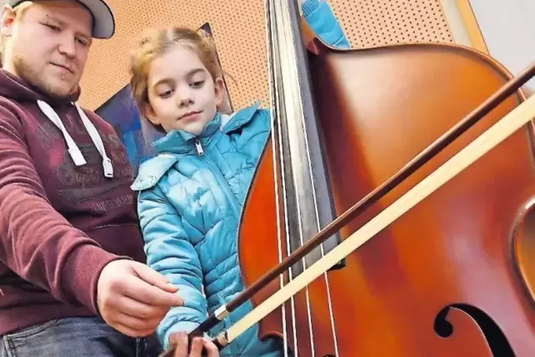 Fabienne probiert gemeinsam mit Lehrer Lukas Hatzis den Bass aus.