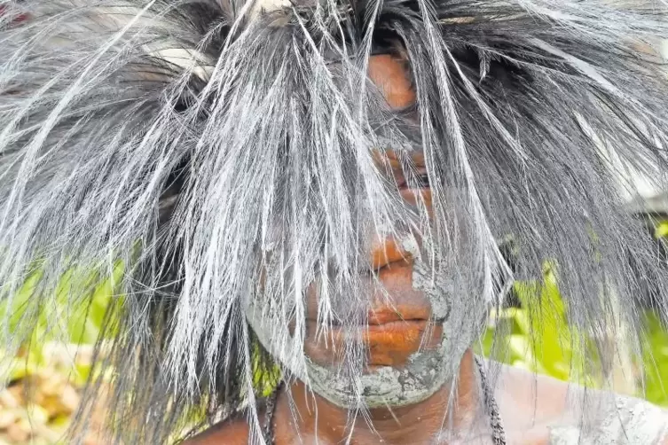 Ungewöhnliche Kopfbedeckung: Zur Begrüßung der Gäste legt der Bogenschütze die Bekleidung seines Stammes an.