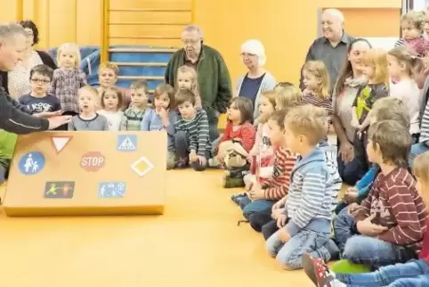 Aufmerksam verfolgen die Kleinen der Kindertagesstätte Odenbach, was Polizist Klaus-Jürgen Lerner ihnen sagt.