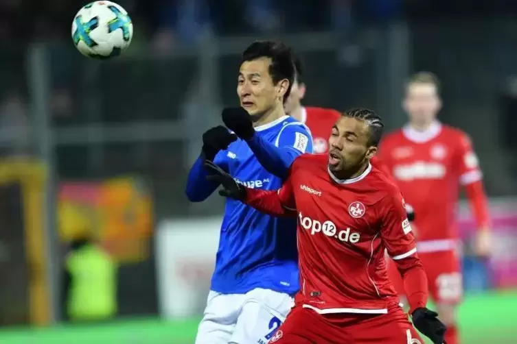 Darmstadts Dong-Won Ji (links) und Kaiserslauterns Leon Guwara kämpfen um den Ball. Foto: DPA
