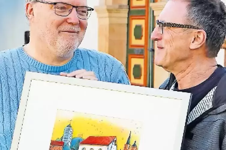 Pfarrer Frank Schuster (links) und Künstler Gerhard Hofmann mit der Farbradierung.