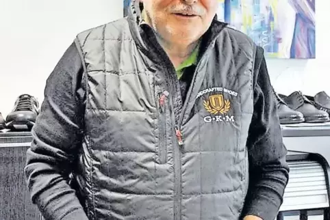 Gerhard Mayer hält zwei Herrenschuhe aus der neuen Frühjahrs-/Sommer-Kollektion in der Hand.