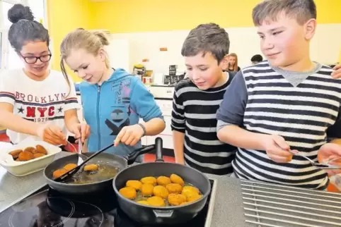 Frederica, Alysha, Jamen und Valeri braten Falafel an.