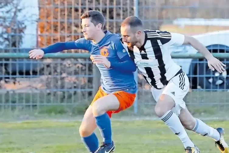 Der Lustadter Johannes Hellmann (in Blau) schirmt den Ball im Duell mit Mahmud Harb ab.