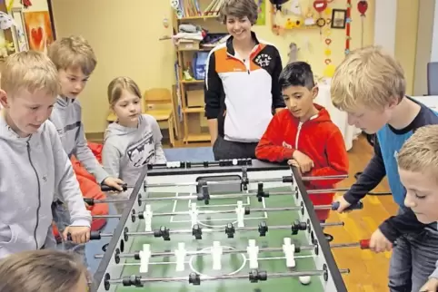 Beim Tischfußball-Workshop in der Stadtbücherei haben neun Kinder einen Riesenspaß.