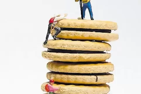Bergsteiger erklimmen einen Berg aus Keksen.