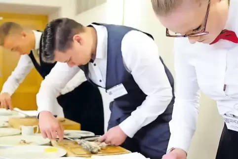 Eine Aufgabe für die Restaurantfachleute: von rechts Jessica Nadler, Hagen Sartorius und Nico Alessandro Veale filetieren Forell