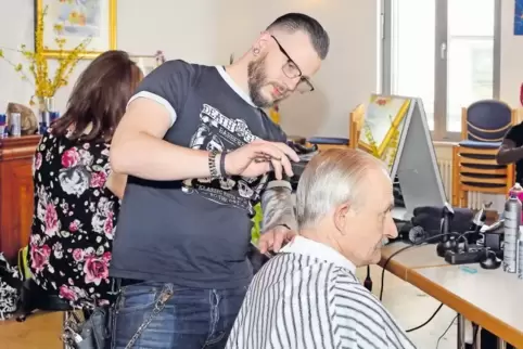 Schnipp, schnapp, Haare ab: Alexander Morell (Mitte) und sein Friseur-Team opfern ihren Ruhetag, um Bedürftigen im Haus der Fami