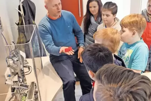 Der Wirtschaftspädagoge Jens Ademmer erklärt den Schülern das Pneumatik-Modell.