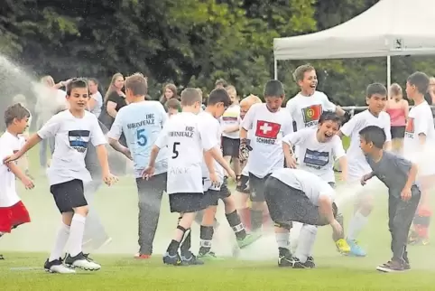 Friedliches Miteinander der Nationen: Nach dem Finale 2014 kühlten sich die Nachwuchskicker bunt gemischt am Rasensprenger.