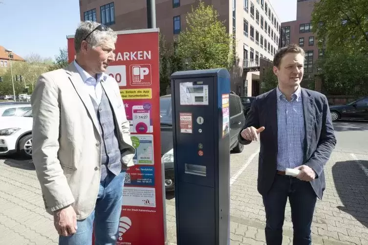Baudezernent Peter Kiefer (links) und Philipp Zimmermann, stellvertretender Geschäftsführer von Smartparking, erklären das Handy