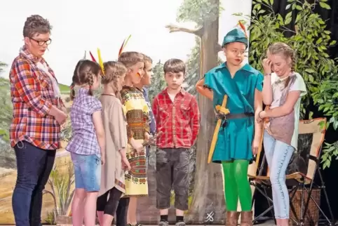 Peter Pan (Kerstin Pletsch) kommt mit Wendy (Leni Schwarz, rechts) im Nimmerland an. Eine Gruppe kleiner Indianer nimmt sie in d