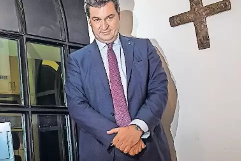 Ministerpräsident Markus Söder neben einem Kreuz in der Staatskanzlei.