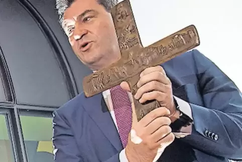 Markus Söder mit einem Kreuz in der Hand.