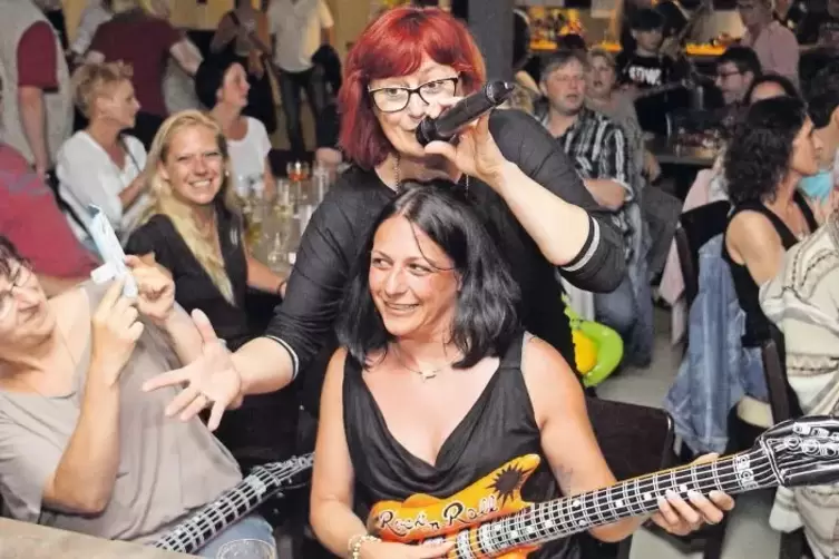 Zum runden Geburtstag zweier Musiker verschenkt die Hubbert House Band aufblasbare Gitarren ans Publikum. Sabine Deller singt am