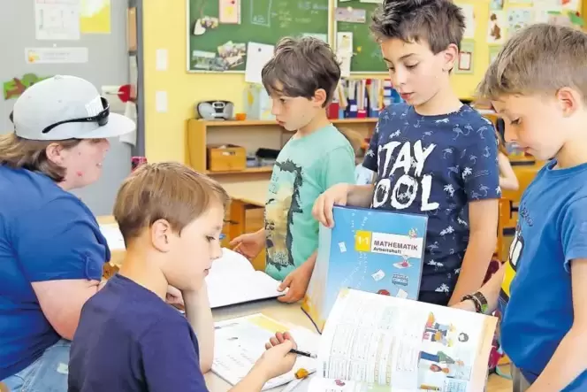 Bei den Hausaufgaben: Die Hortkinder der ersten und zweiten Klasse zeigen Erzieherin Susanne Daßler, was sie an diesem Nachmitta Bei den Hausaufgaben: Die Hortkinder der ersten und zweiten Klasse zeigen Erzieherin Susanne Daßler, was sie an diesem Nachmitta