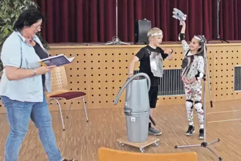 Chorleiterin Dagmar Rosemann (links) mit Watt (Andreas), der mit einem Sandstreuer bewaffnet ist, und Volt (Ruby), die über eine