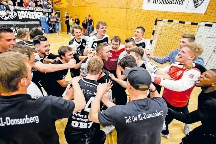 Freuen sich riesig über den Klassenerhalt und feiern mit den Fans: Die Handballer des TuS Dansenberg.