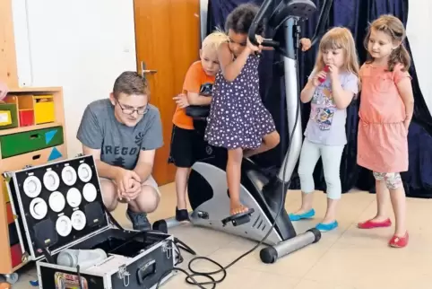 Erzieher Simon Konietzka mit Kindern der Kita Grashüpfer bei einem Aktionstag in Laumersheim. Mit dem Energiefahrrad erzeugen si