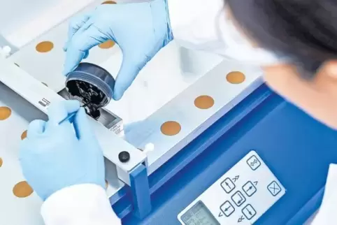 Für die Herstellung von kleinen Testbatterien gießt eine BASF-Mitarbeiterin eine Paste aus Kathodenmaterial auf eine Aluminiumfo